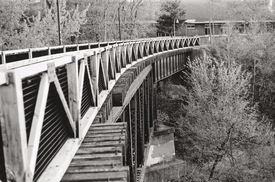 Black and White picture of curved wooden foot bridge